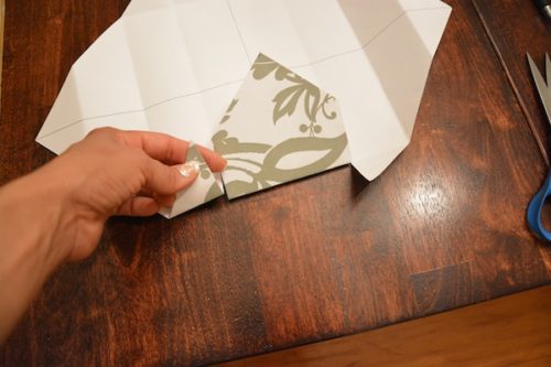 How to Make a Gift Box From Scrapbook Paper - Snip both folds up to the edge of the corner. - Thrift Diving