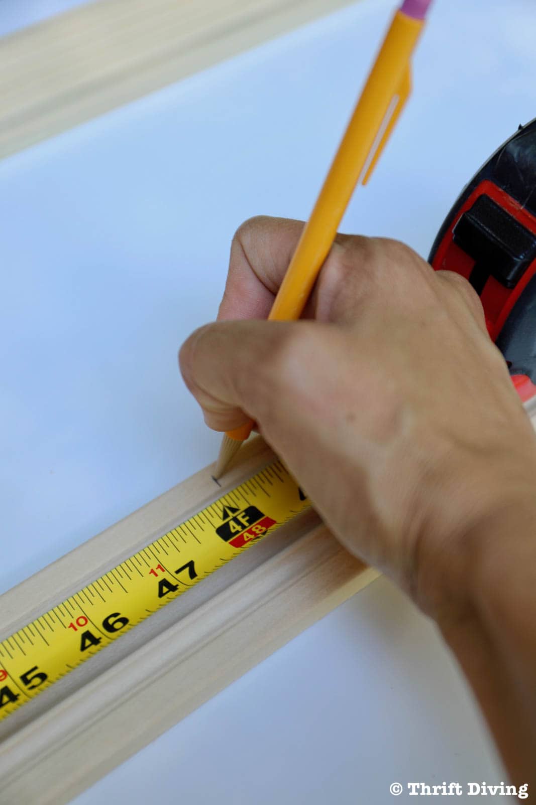 How to Make a Big DIY Whiteboard - Mark the length of the wood trim. - Thrift Diving