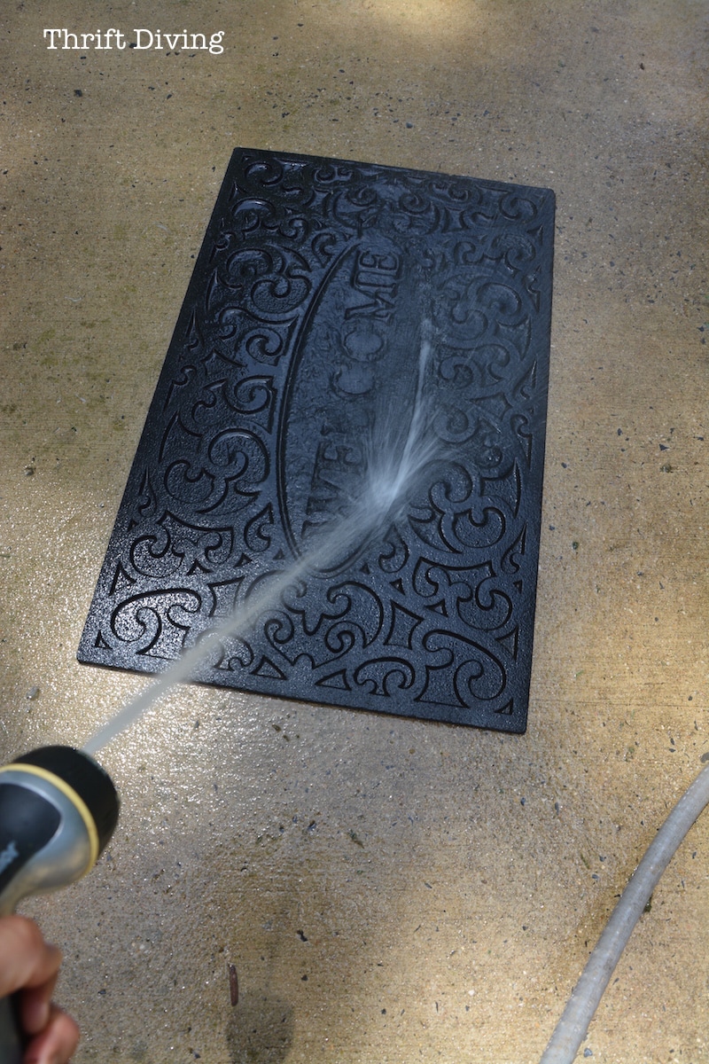 How to Paint a Custom Welcome Mat - Use a pressure washer to remove the excess dirt from your rubber welcome mat before painting it. - Thrift Diving