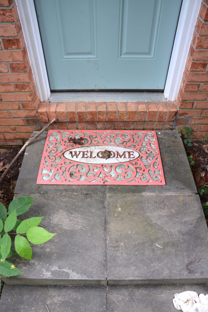 Painted welcome mat is dirty but still looking good after years outdoors. - Thrift Diving