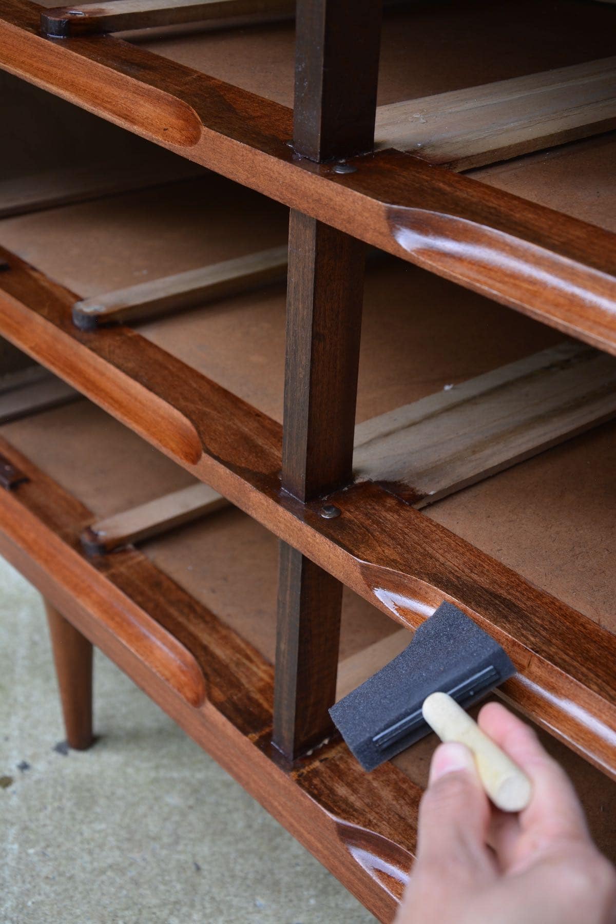 Mid-Century Modern Dresser Makeover Stripped and Refinished - Adding coats of topcoat to the front of the dresser. - Thrift Diving