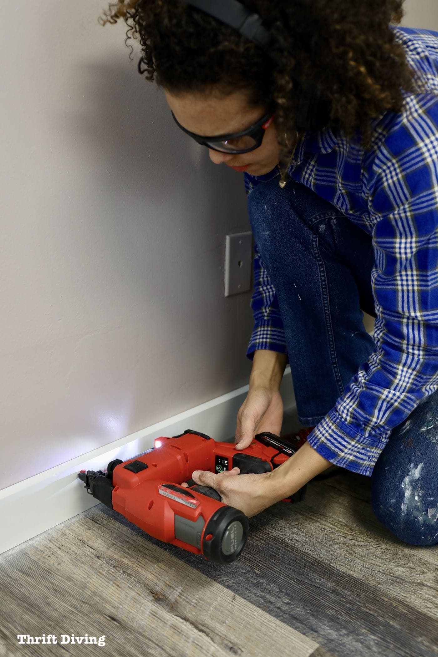 Installing baseboard molding with an 18 gauge nailer.