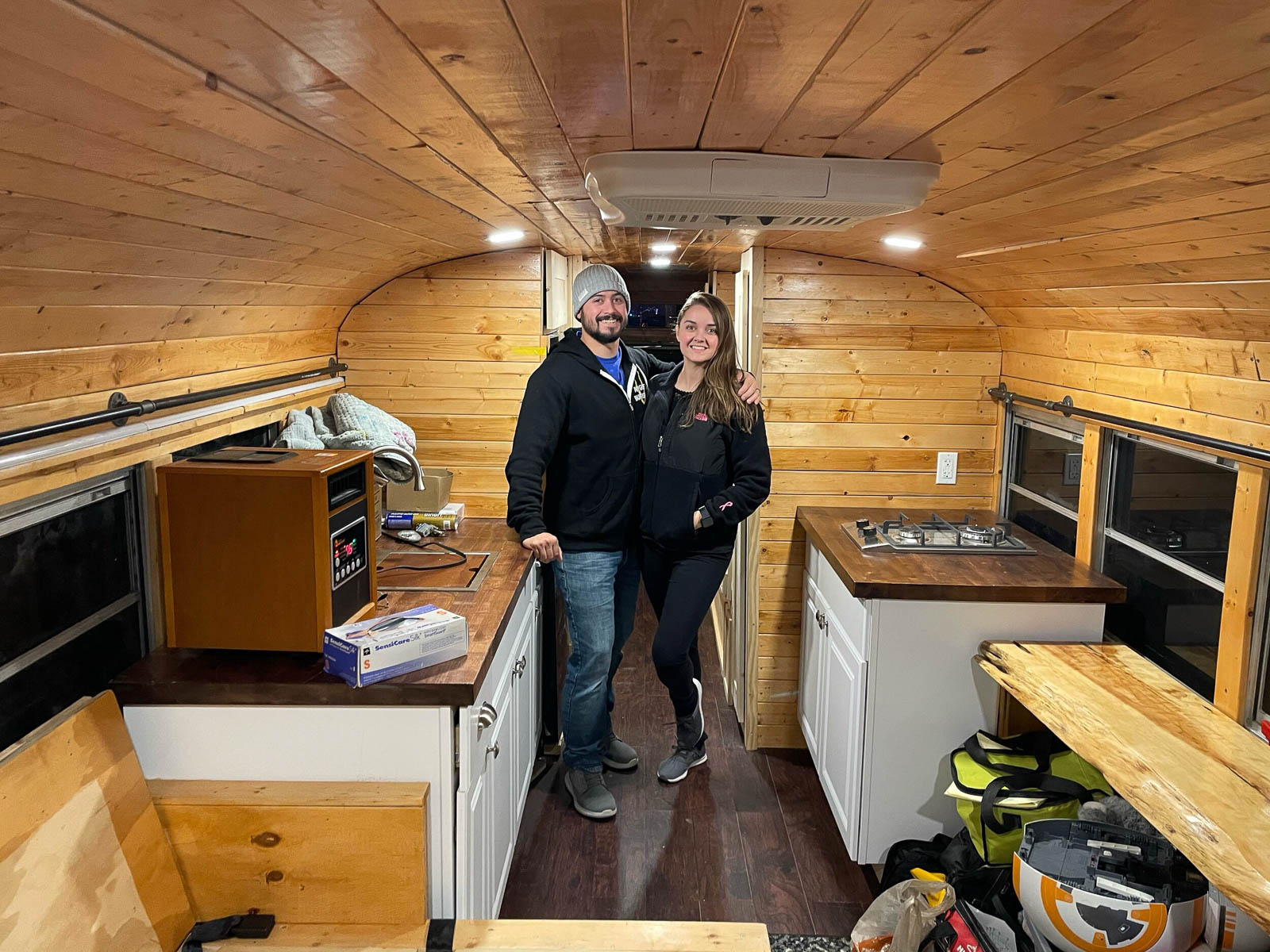 Adam and Chelsea Gibson working on their school bus renovated into a tiny house.