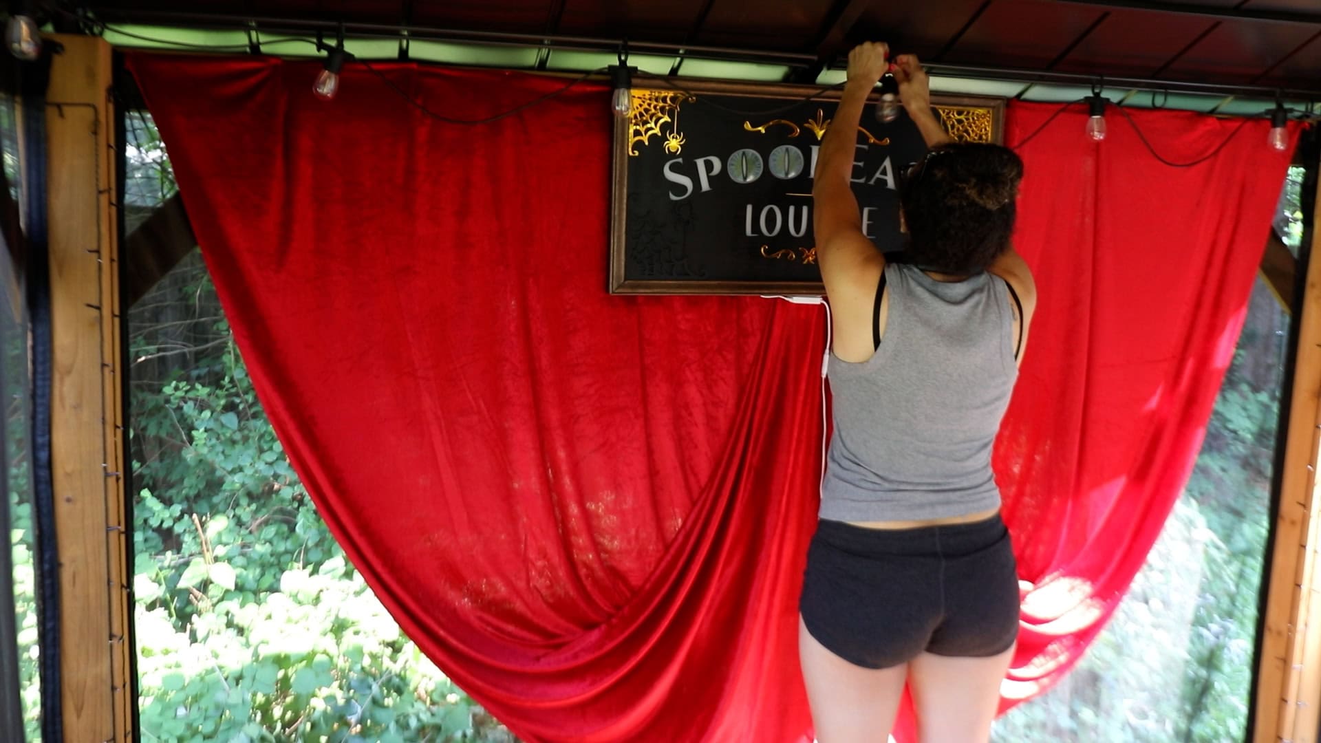 Stapling red velvet fabric in a gazebo.