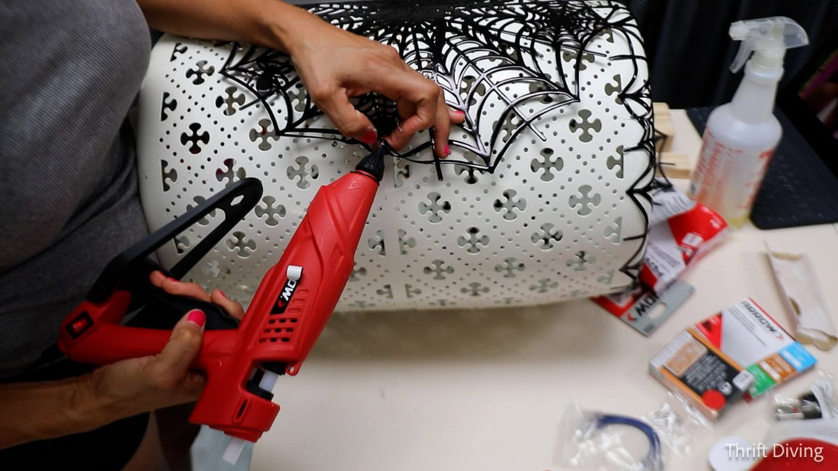 Hot gluing spider place mats with hot glue.