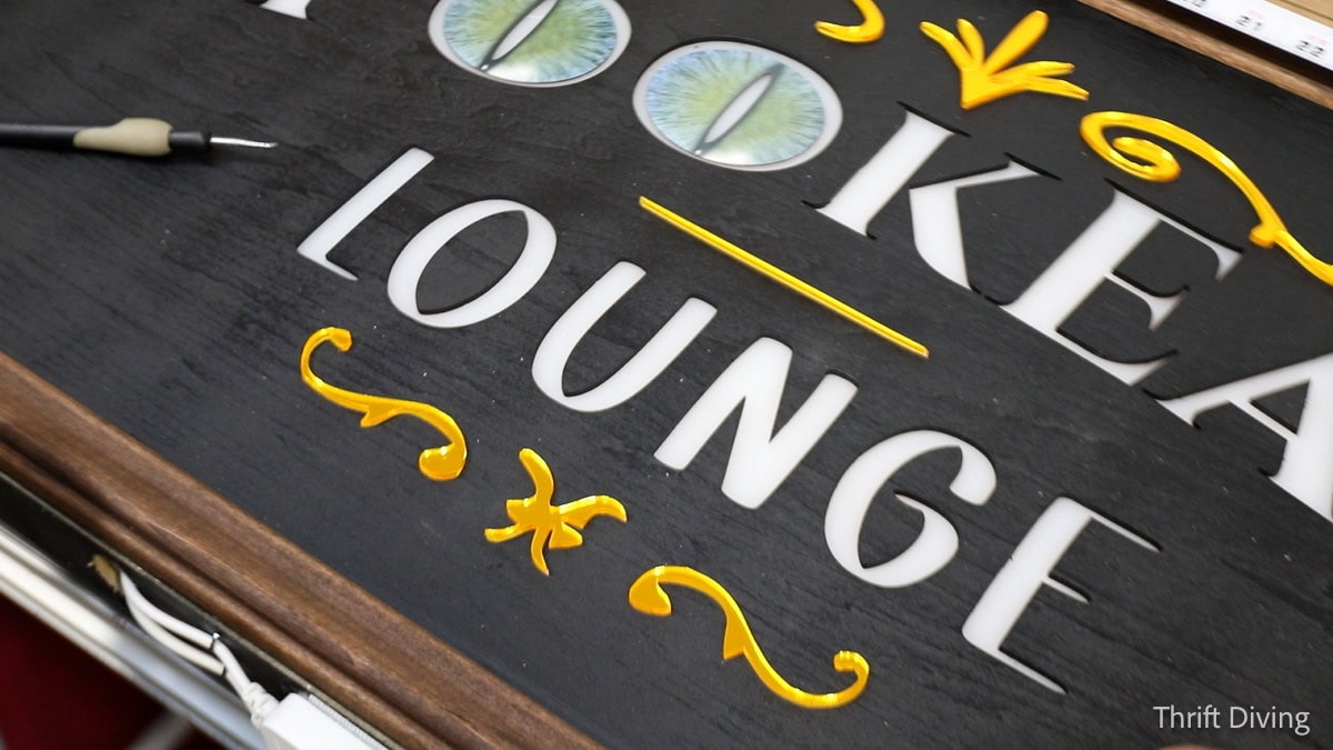 Attaching mirror acrylic to custom light-up sign cut with a laser engraver.